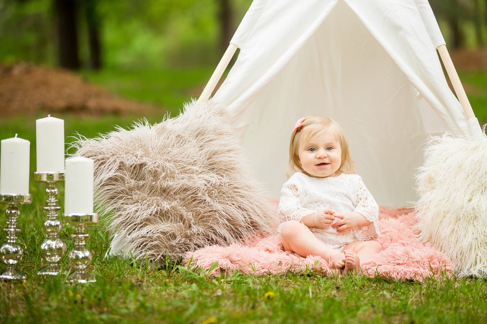 Photographs of a toddler under a teepee with fuzzy pillows
