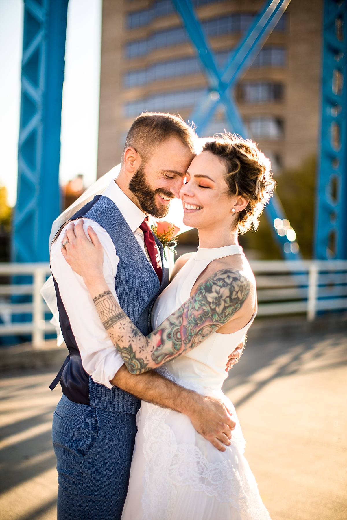 Wedding photographs of a smiling bride and groom at the Grand Rapids Blue Bridge