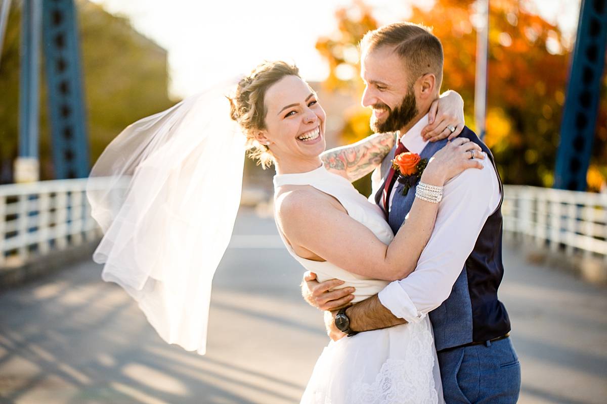 Wedding photographs of a smiling bride and groom at the Grand Rapids Blue Bridge