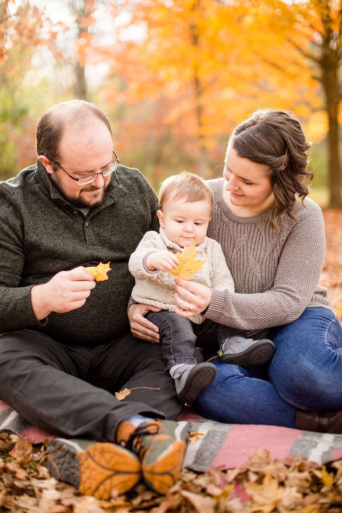 Playing with leaves at a Fall family photographs at Lincoln Brick Park in Grand Ledge, Michigan