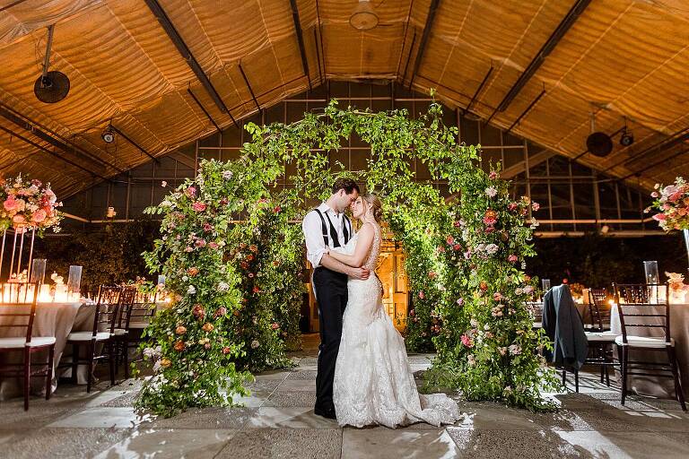 Nightime Wedding photographs at MSU Horticulture Gardens greenhouse with large floral arch