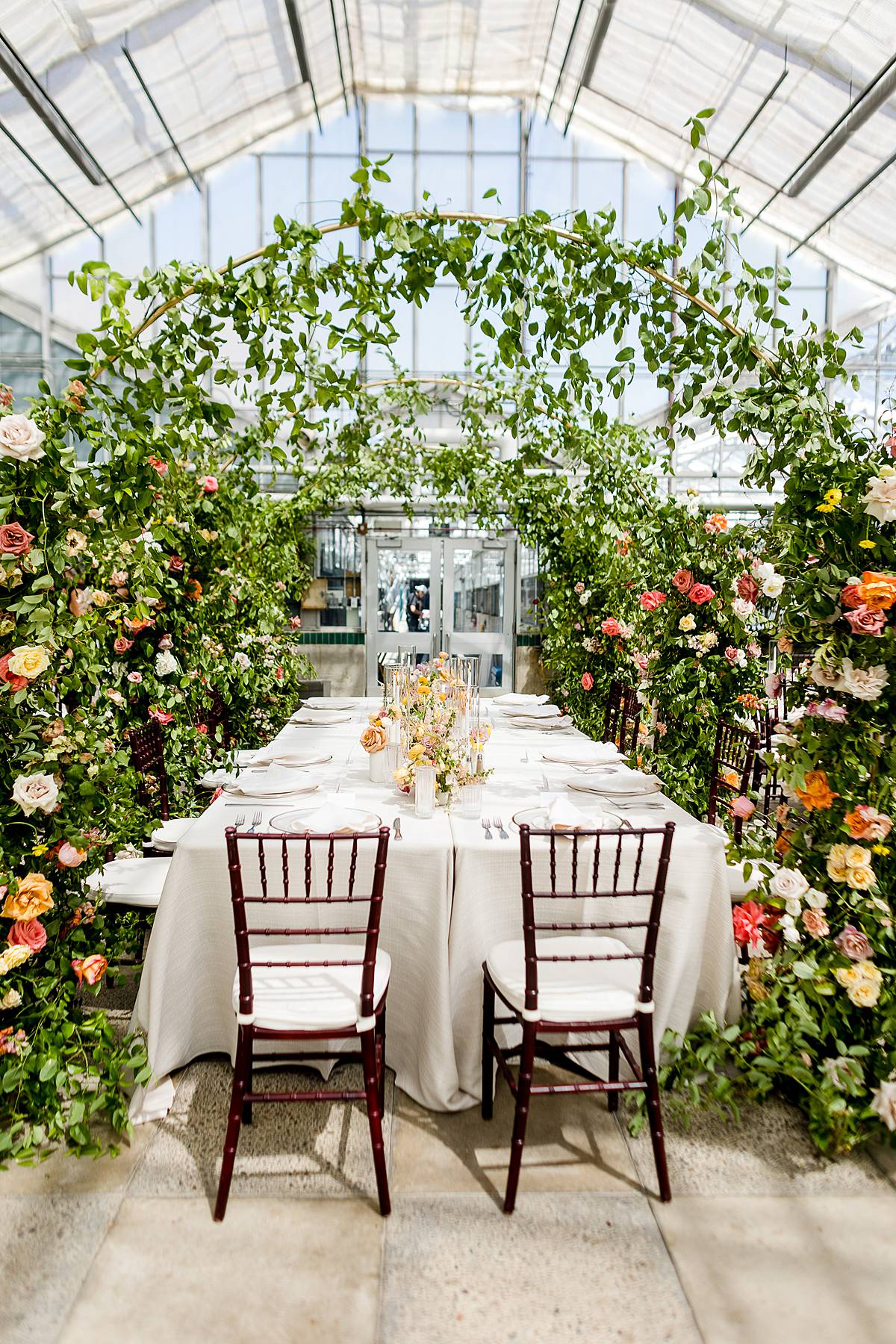 MSU wedding with incredible floral arch décor in the Michigan State University Horticulture Garden Greenhouse reception area