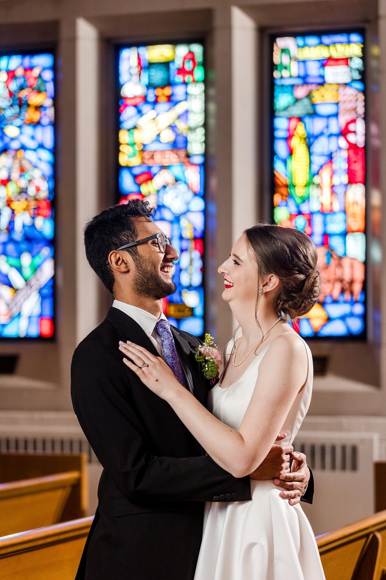 Bride and groom in front of the stained glass at the Alumni Chapel, MSU East Lansing Michigan