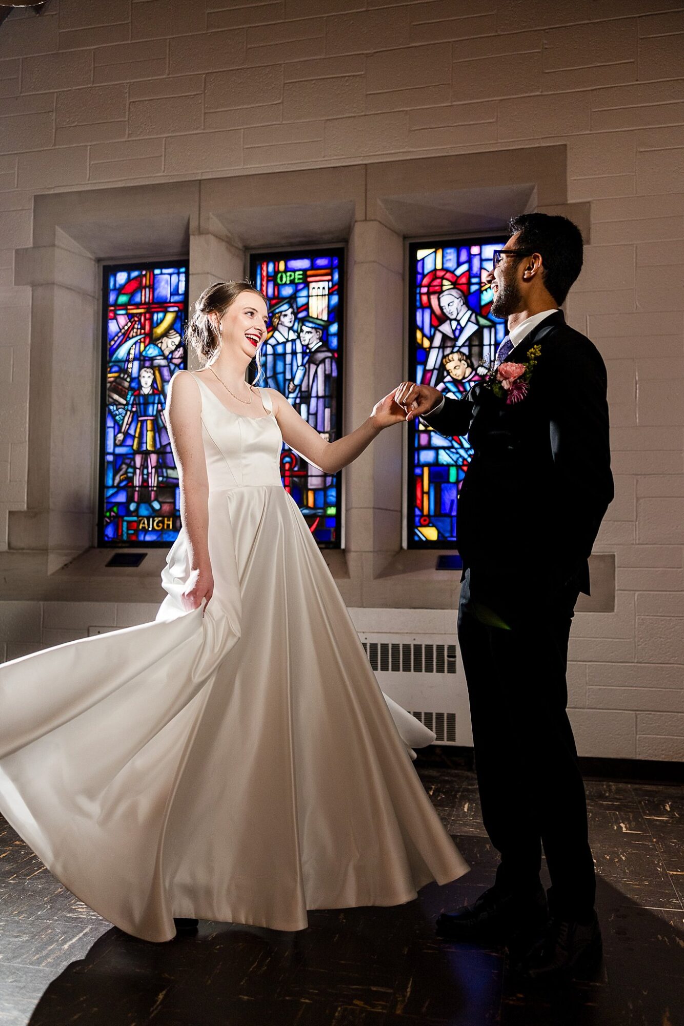 Bride and groom in front of the balcony stained glass at the Alumni Chapel, MSU East Lansing Michigan